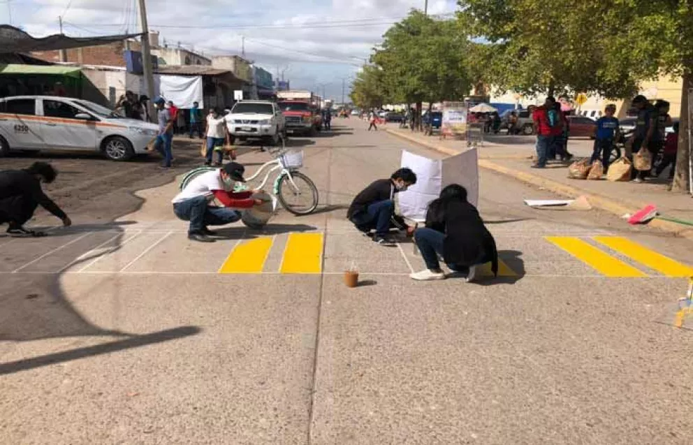 Jóvenes pintan senda peatonal frente a Ley Express Villa Juárez